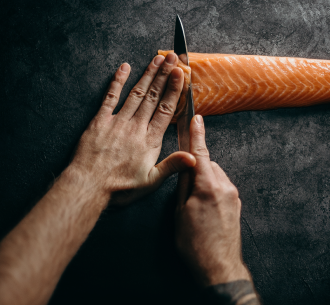 Salmon fillet being cut with a knife